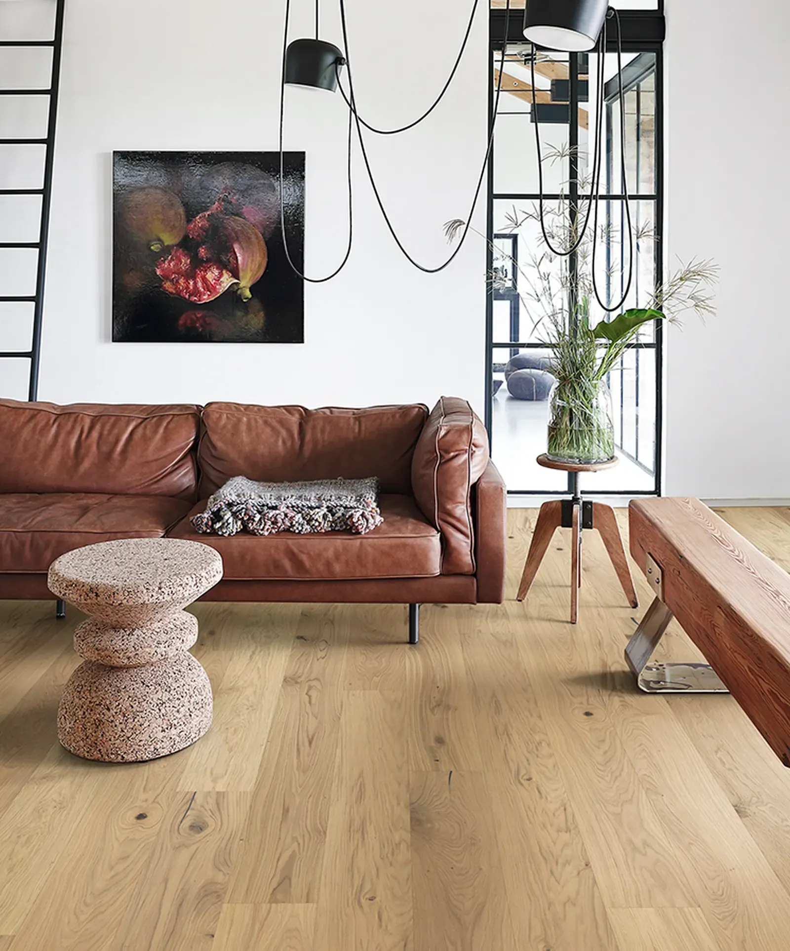 Phòng khách đương đại với sàn gỗ sáng màu, ghế sofa da và trang trí nghệ thuật.